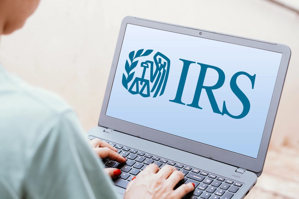 view of person looking at laptop screen with IRS logo on the screen
